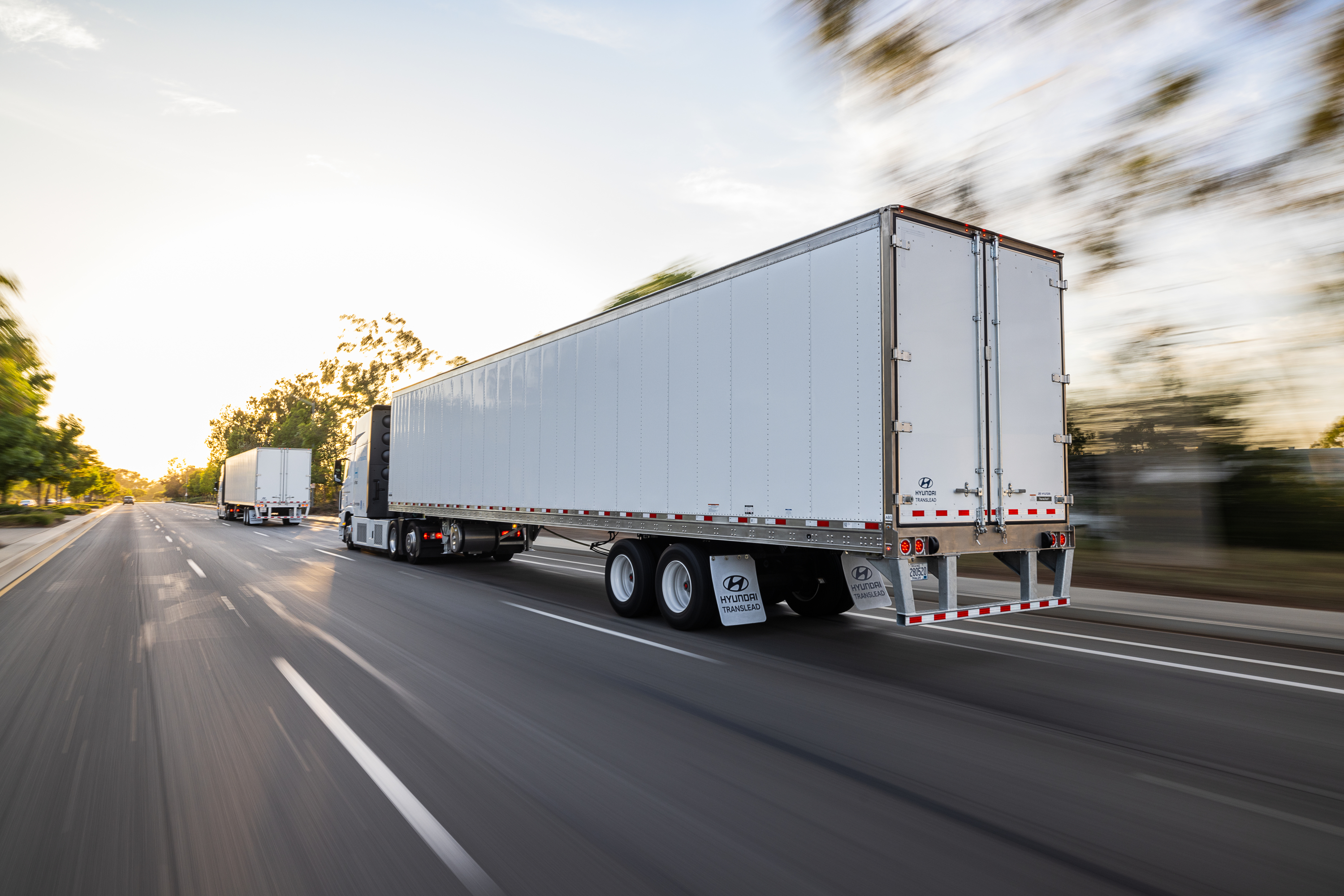 A Utility Trailer 3000R Multi-Temp semi trailer parked on a beach at sunset with its back doors open