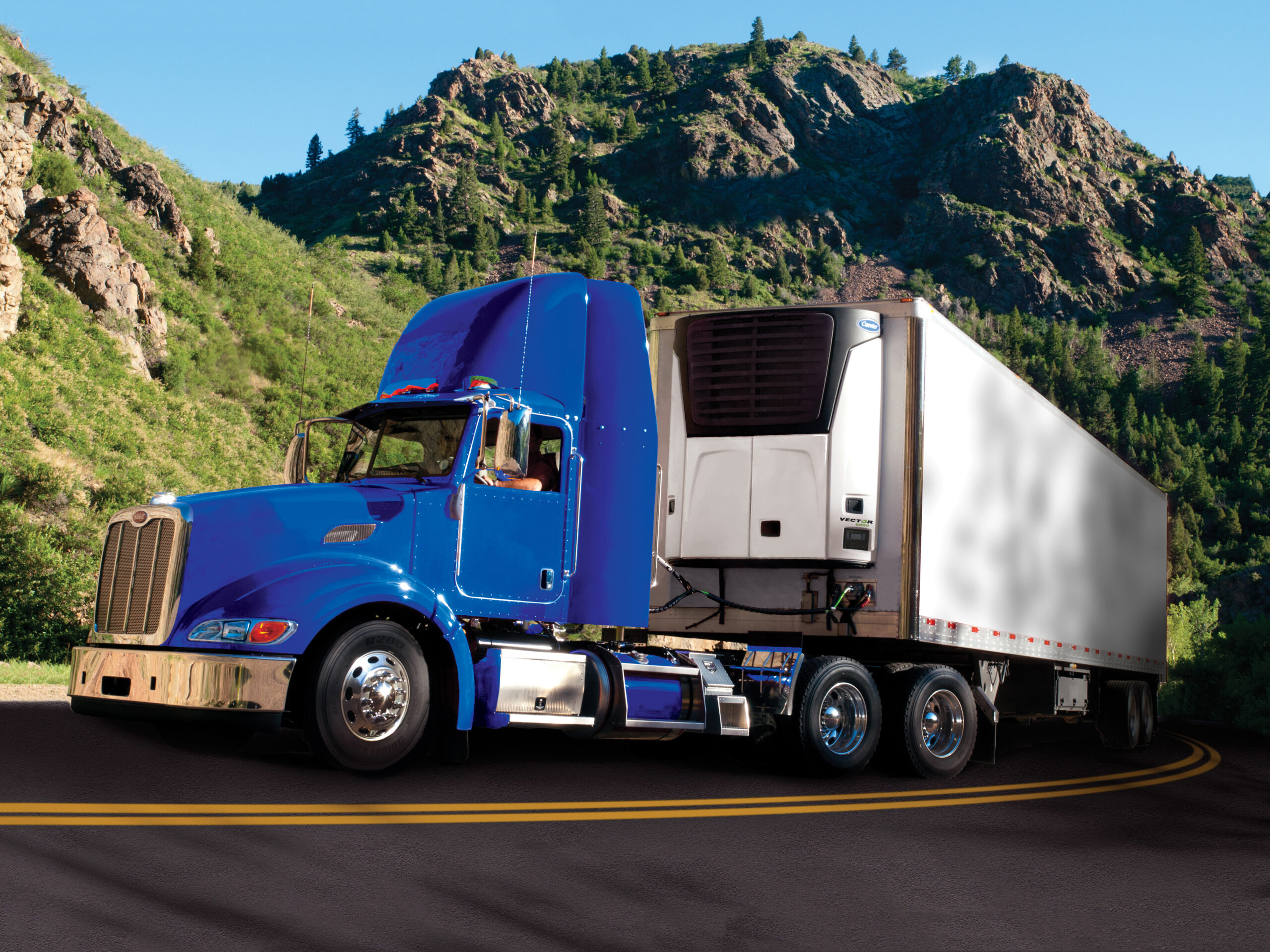 A Utility Trailer 3000R refrigerated semi trailer parked on a beach in the evening.